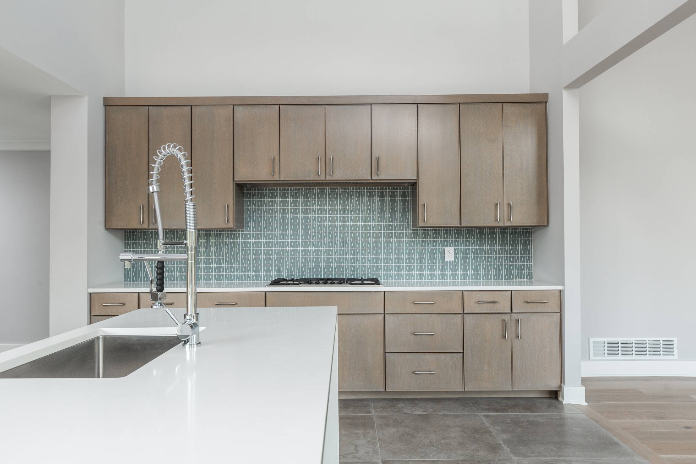 Custom kitchen with quartz countertops, designer backsplash, and premium cabinetry by Eaton Custom Homes
